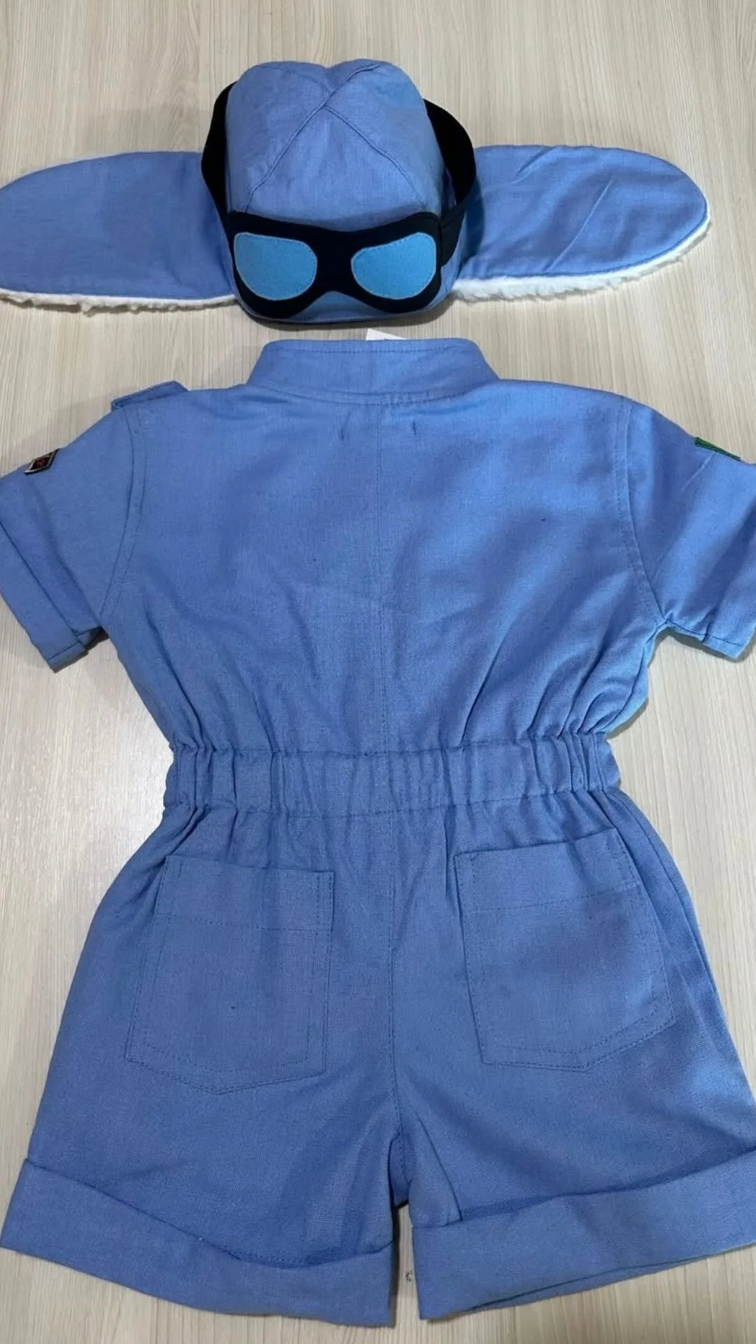 Macacão Aviador visto pelas costas com alças reguláveis em fivela metálica, viés contrastante cáqui acabando as bordas e pespontos duplos